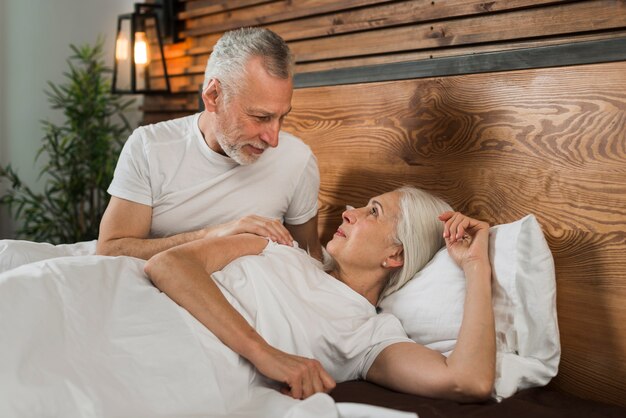 Elder couple sitting in bed at home