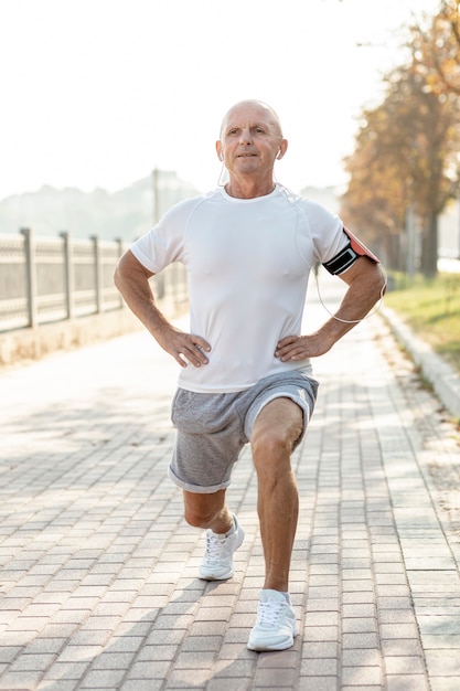 Free photo elder man doing exercises outdoors