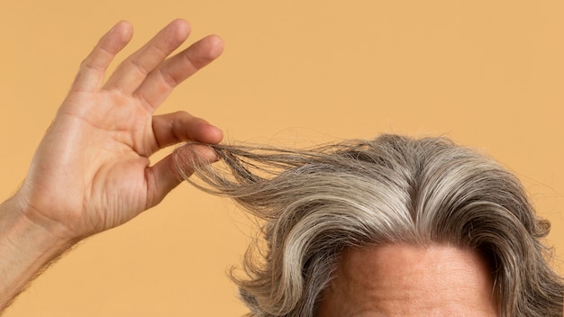 Elder man holding his gray hair