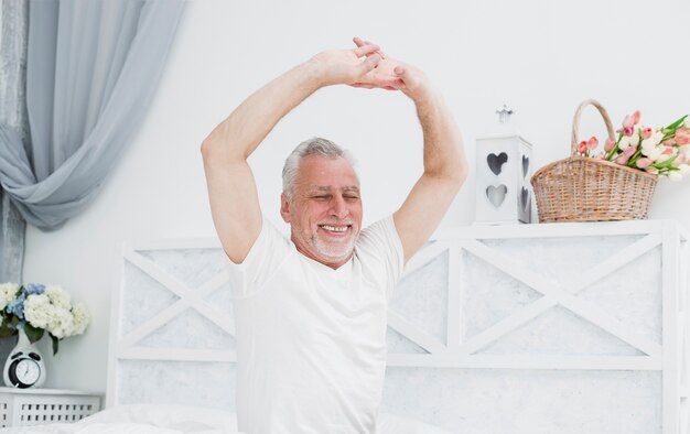 Elder man waking up in the bed