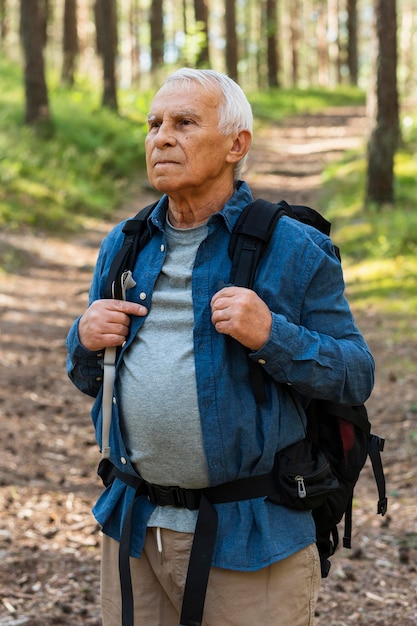 Elder man with backpack exploring nature