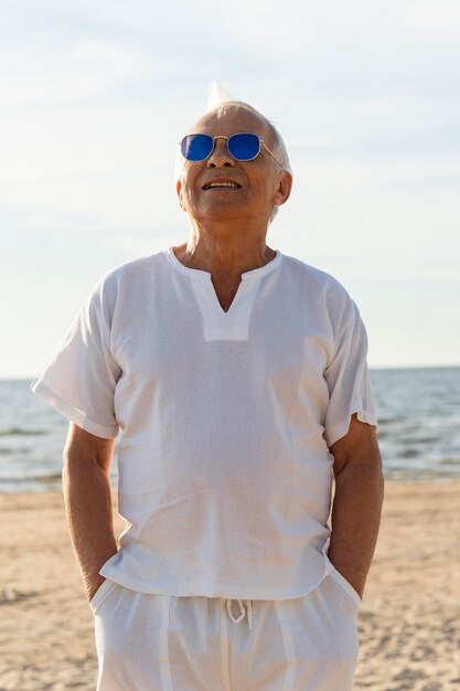Elder man with sunglasses by the beach