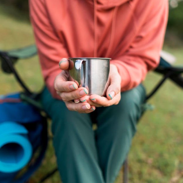 Free photo elder tourist woman holding metal cup outdoors