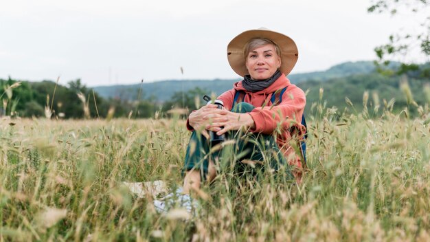 Старшая туристская женщина в природе и траве