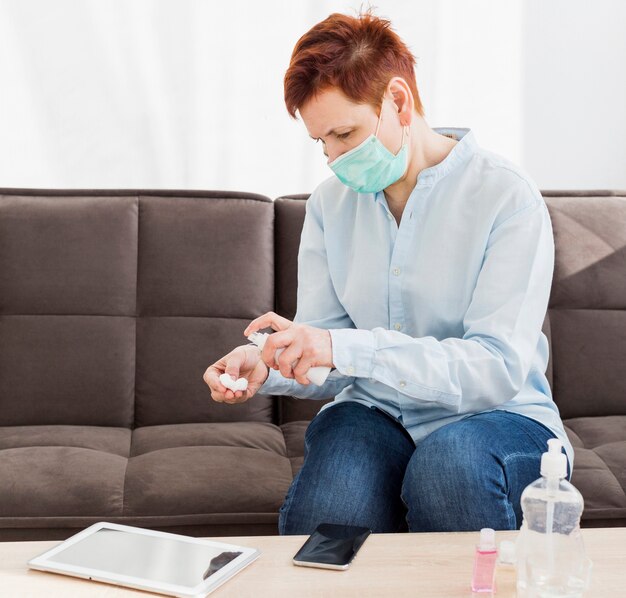 Elder woman disinfecting her devices at home