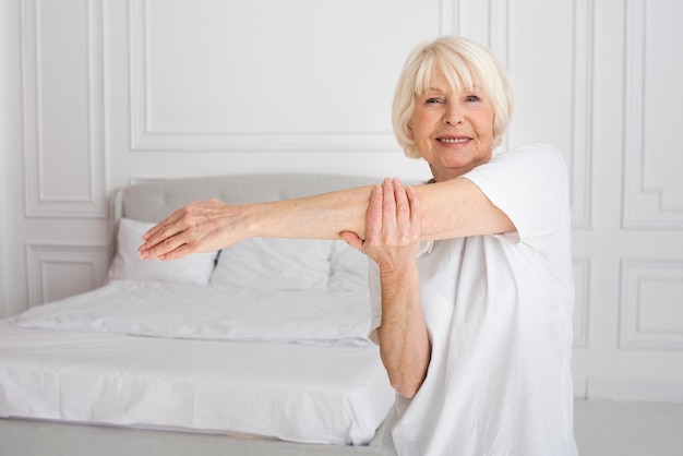 Free photo elder woman doing sport in the bedroom