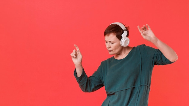 Free photo elder woman listening music and dancing