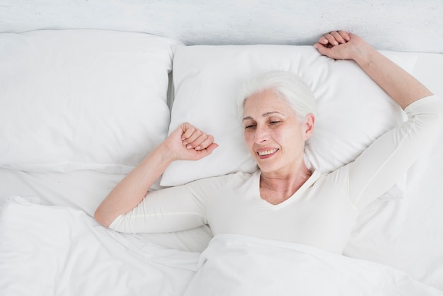 Elder woman waking up in the bed