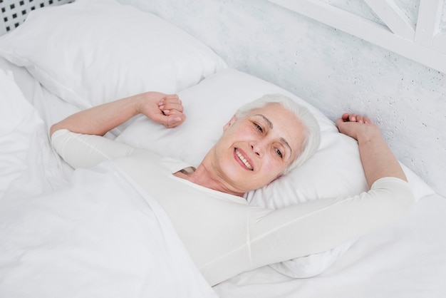 Elder woman waking up in the bed