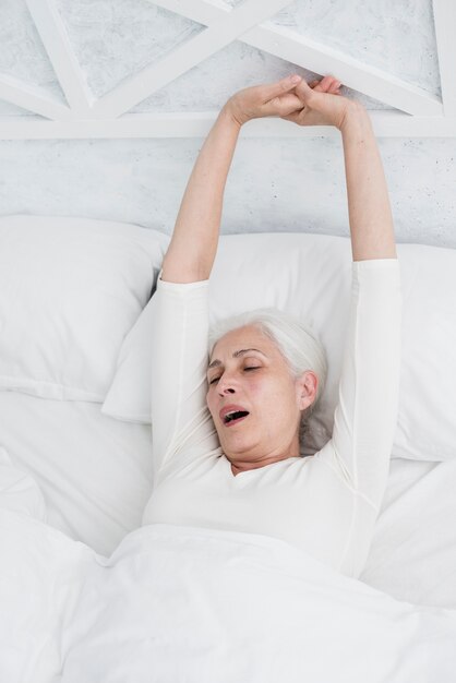 Elder woman waking up in the bed