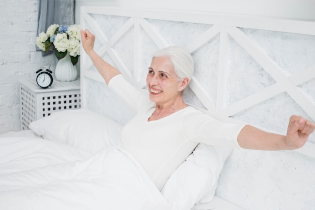 Elder woman waking up in the bed