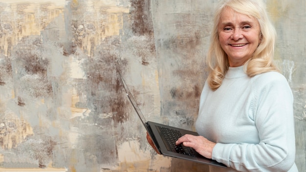 Free photo elder woman with laptop at frozen window