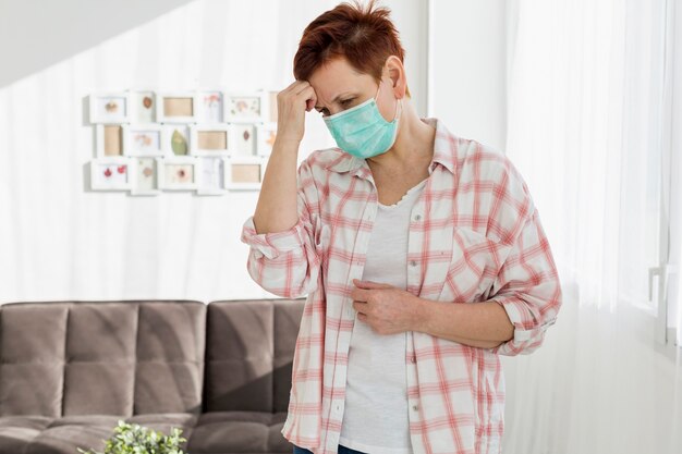 Elder woman with medical mask feeling ill