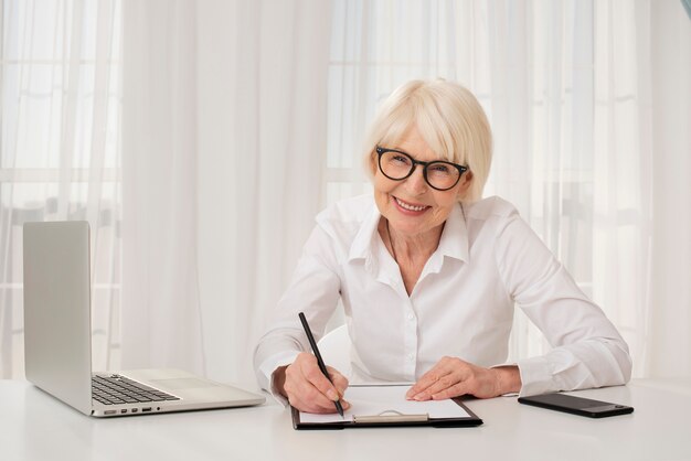 Elder woman writing in a clipboard