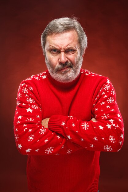赤いクリスマスセーターで高齢者の怒っている人