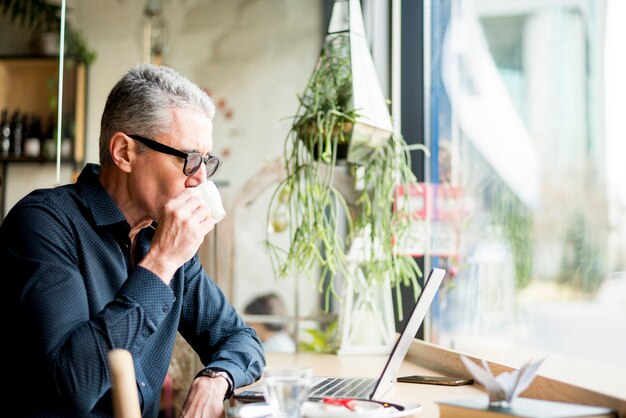 Elderly businessman having coffee