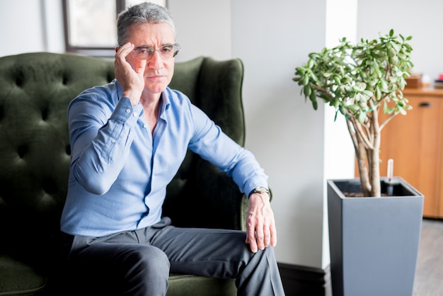 Elderly businessman posing on armchair