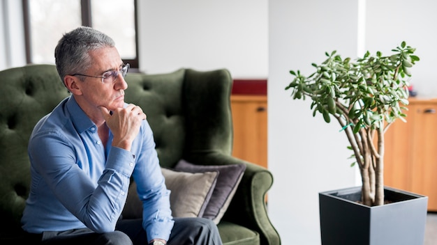 Elderly businessman posing on a sofa