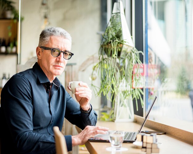 Elderly businessman posing  with coffee