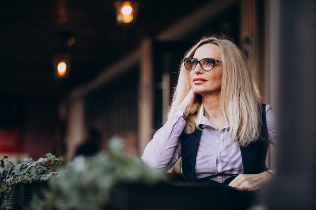 Elderly businesswoman sitting outside the cafe