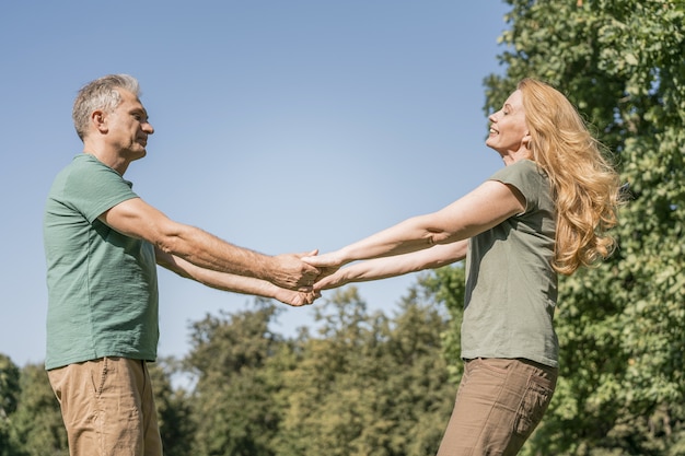 Free photo elderly couple dancing in the park