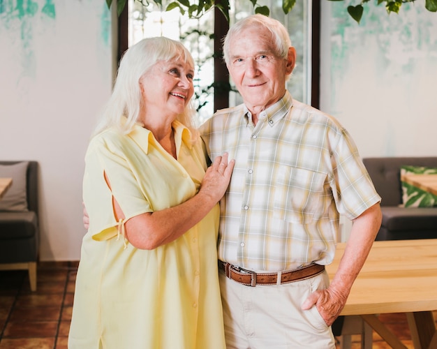 Elderly couple embracing standing at home