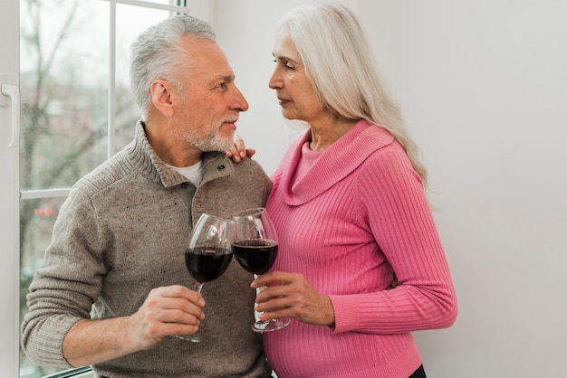 Free photo elderly couple enjoying glass of wine