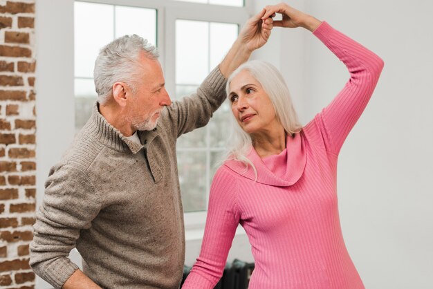 Elderly couple at home dancing