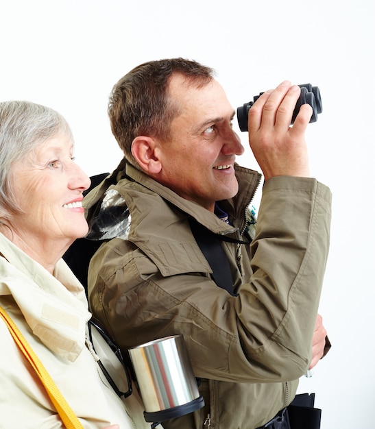 Elderly couple looking through binoculars