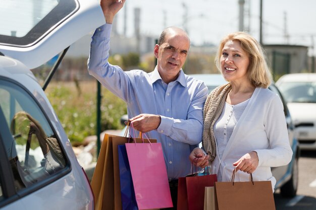 Elderly couple putting bags  in trunk