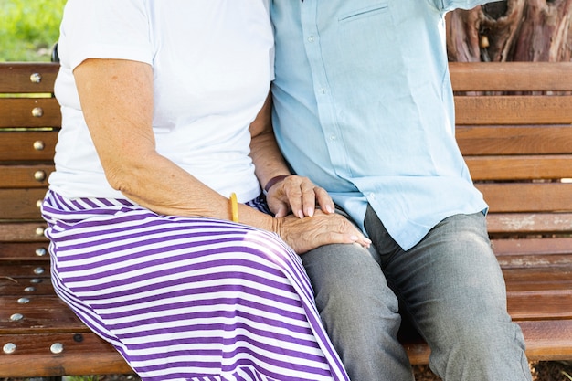 Elderly couple sitting on a bench close-up