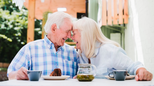 Free photo elderly couple sitting head to head drinking tea