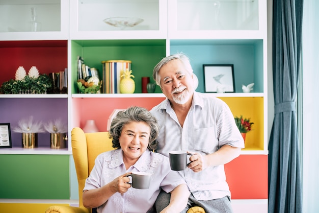 Elderly Couple Talking together and drinking coffee or milk