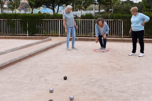 Free photo elderly friends playing petanque