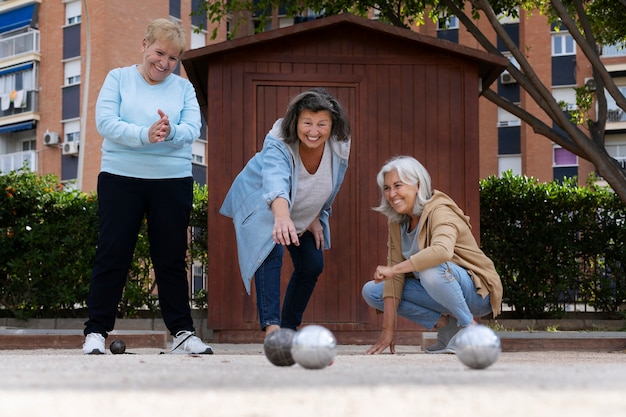 Free photo elderly friends playing petanque