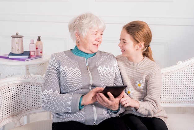 Free photo elderly grandma reading with her granddaughter