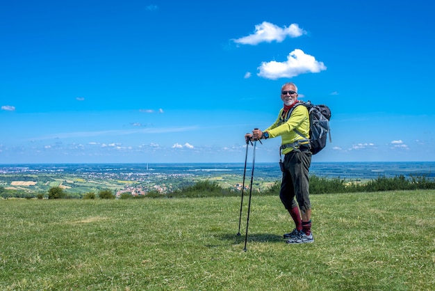 Elderly hiker male smiling after a hike on a hill