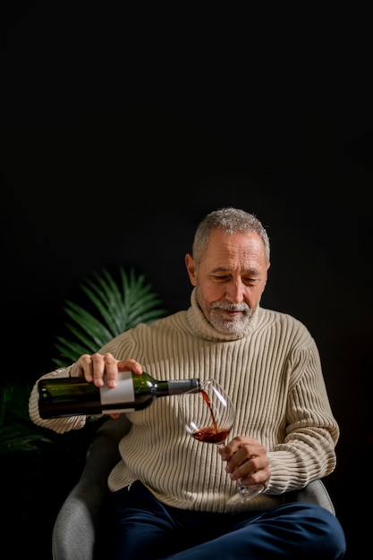 Free photo elderly male pouring wine