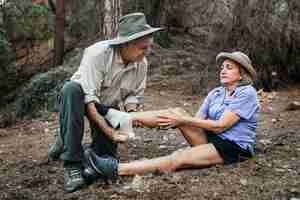 Free photo elderly man bandaging his wife's ankle