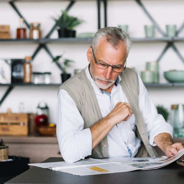 An elderly man reading newspaper