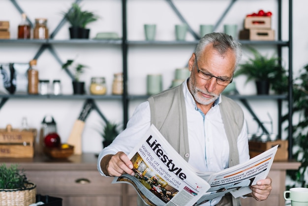 Free photo an elderly man reading newspaper