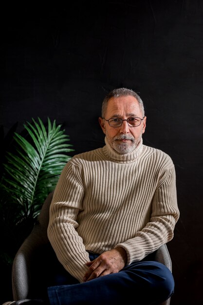 Elderly man sitting near plant