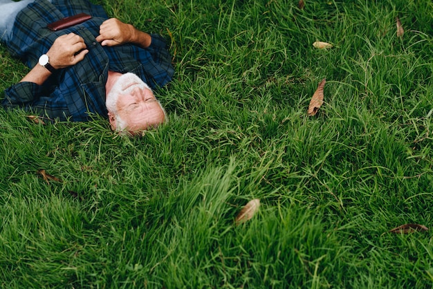 Foto gratuita uomo anziano che dorme sull'erba verde