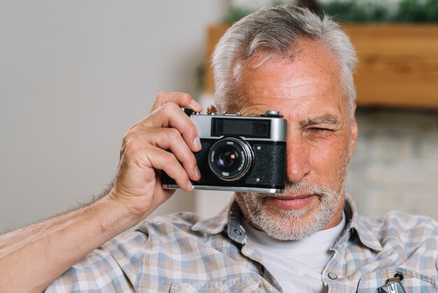 An elderly man taking photo from camera