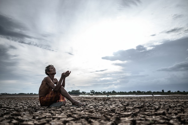 An elderly man was sitting asking for rain in the dry season, global warming