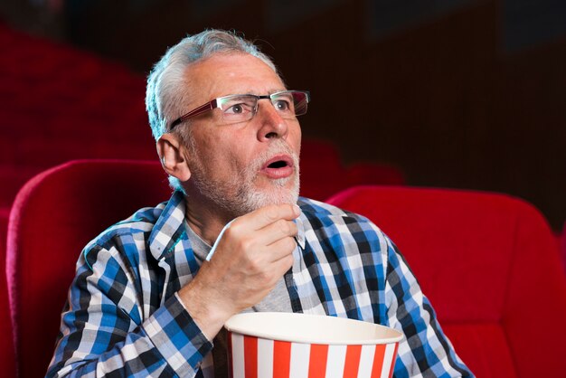 映画館で映画を見ている老人