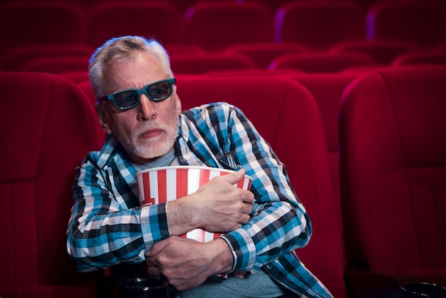 Free photo elderly man watching movie in cinema