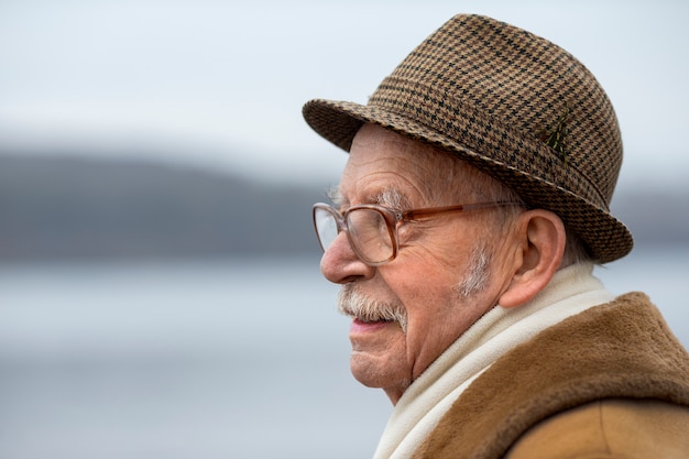 Free photo elderly man wearing hat side view