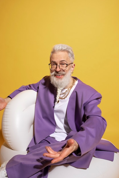 Elderly man with chain necklaces posing