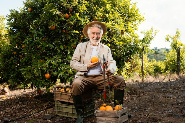 Foto gratuita uomo anziano con arance fresche